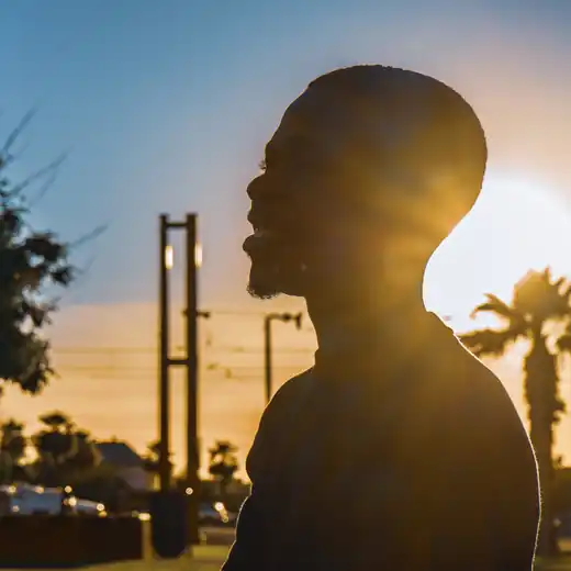 Backlit profile portrait of a smiling man at sunset