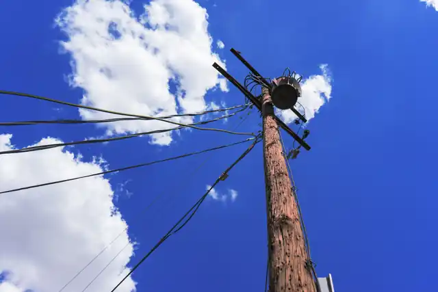 Utility pole and diagonal wires against a deep blue Arizona sky