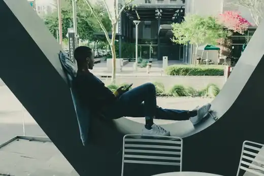 Man seated within a large circular architectural structure in an urban courtyard